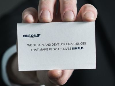 Nahaufnahme einer Hand, die eine Visitenkarte mit der Aufschrift „We design and develop experiences that make people’s lives simple“ hält. Symbolisiert die Automatisierung von Prozessen durch die KI-Assistentin Martina, die Briefings per E-Mail in Präsentationen umwandelt und Teams bei wiederkehrenden Aufgaben entlastet.